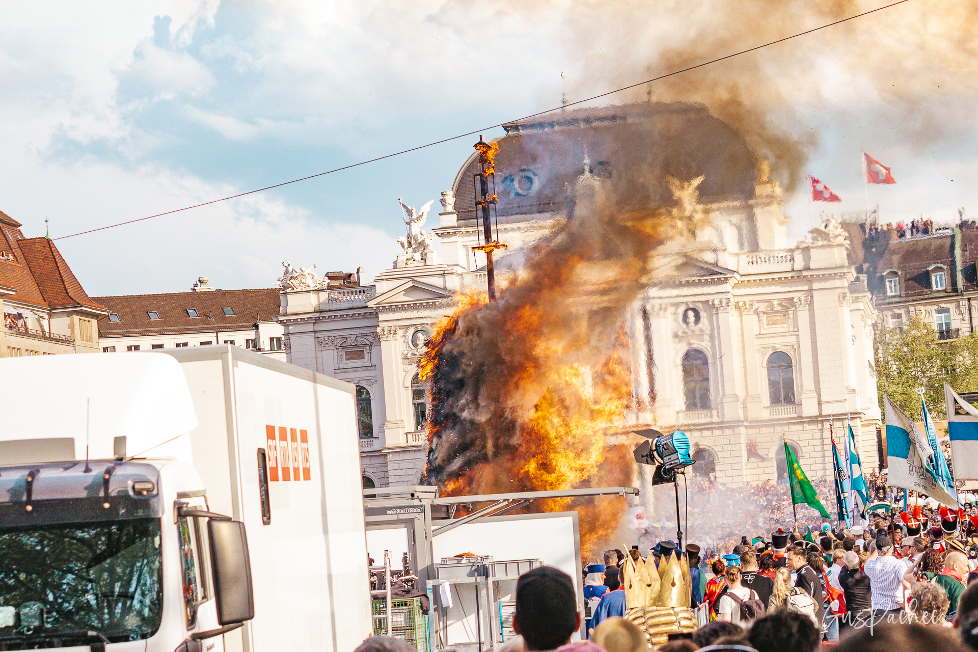Sechseläuten — Böögg burning at full intensity in front of Zürich Opera House with crowd and guild flags
